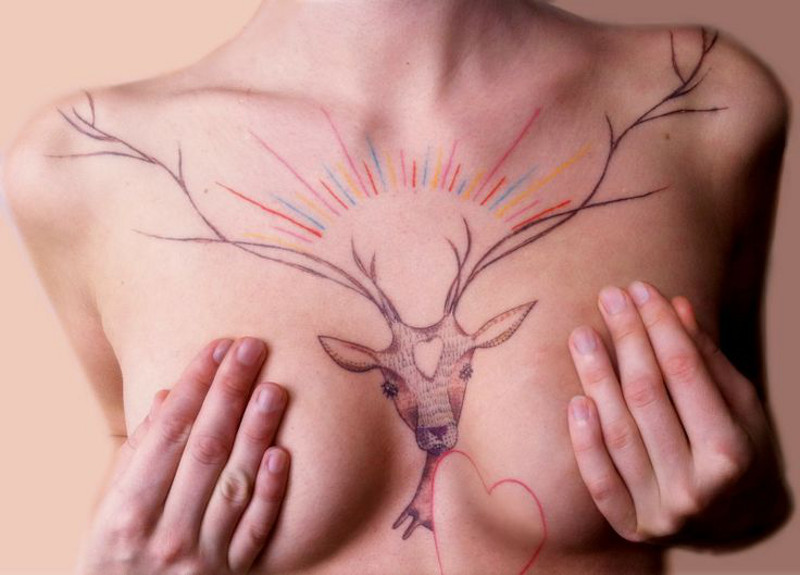 Татуировка рога на женской груди