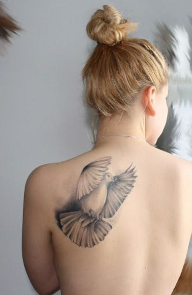 Татуировка голубь на спине девушки